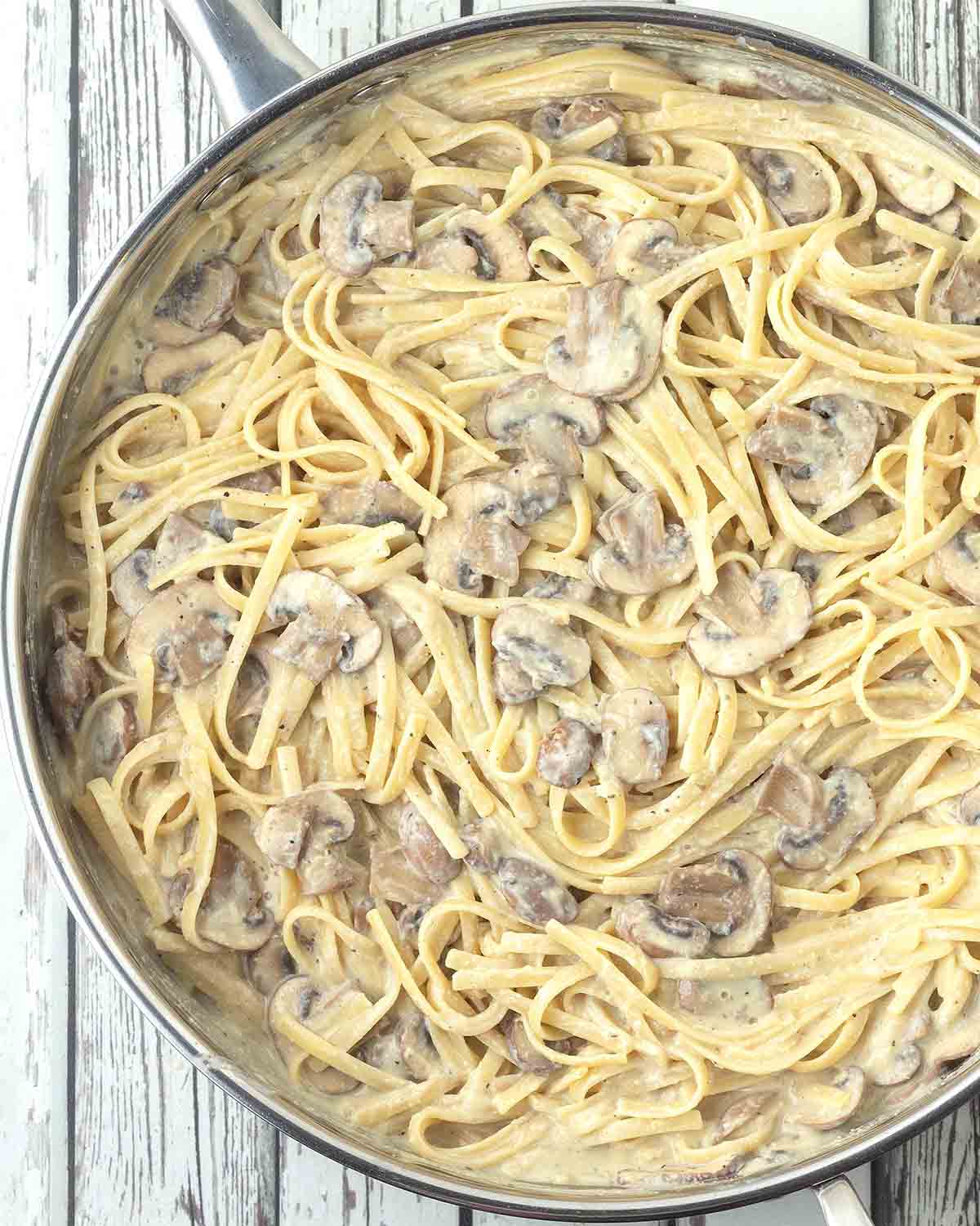 An overhead shot of a large pan filled with freshly made vegan mushroom pasta.