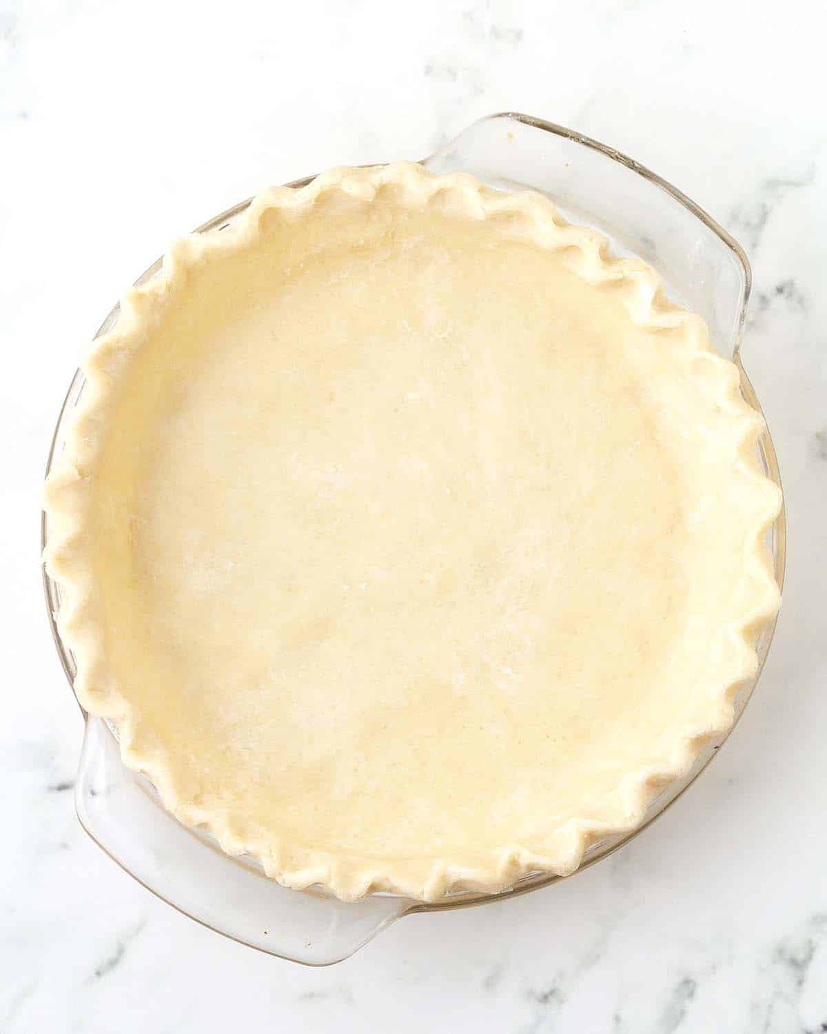An overhead image of a pie crust ready to be filled and baked.