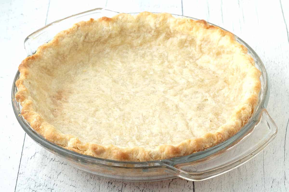 A close-up shot of a fully baked empty pie crust, the crust is golden brown.