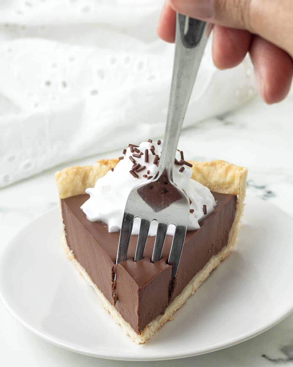 A fork taking a piece out of a slice of dairy-free chocolate pie.