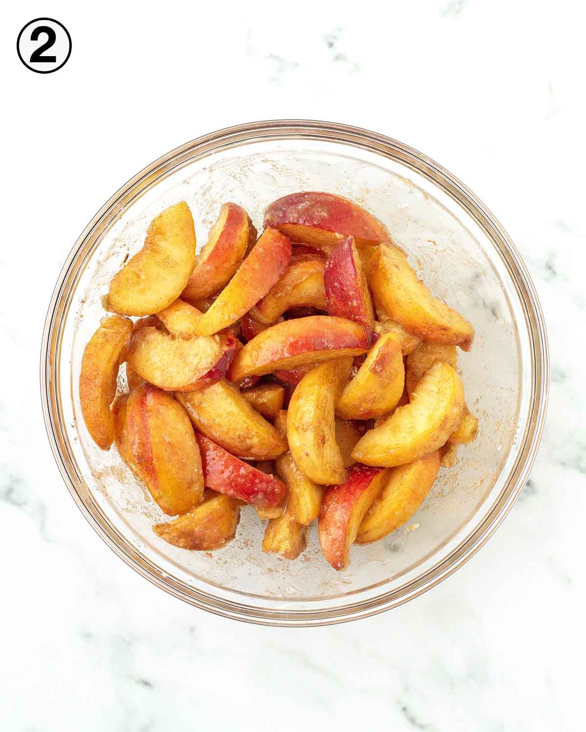 A glass bowl of peach galette filling.