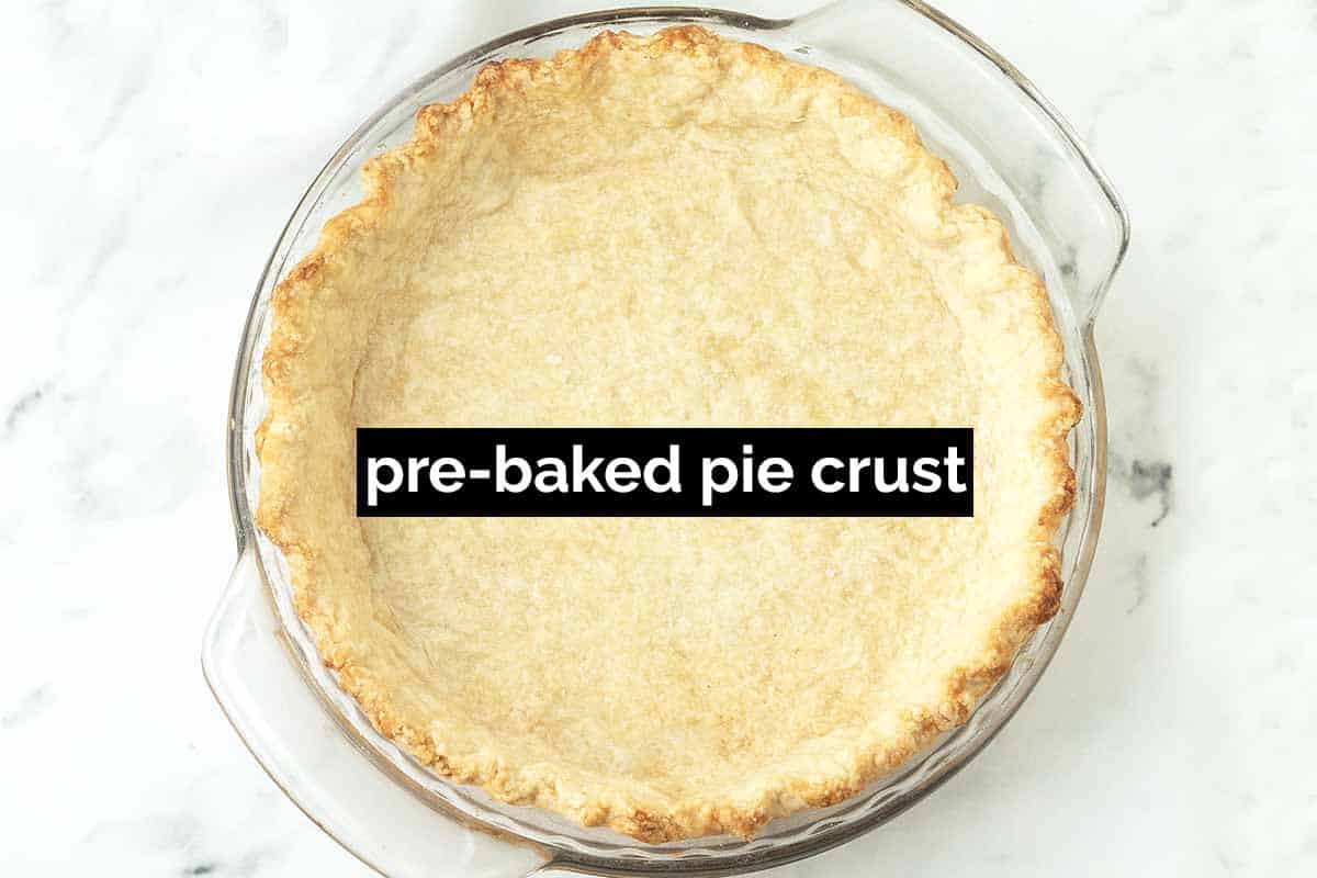 A fully baked empty pie crust with a text overlay that says pre-baked pie crust.