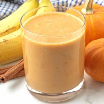 A close up image of a pumpkin smoothie in a glass cup.