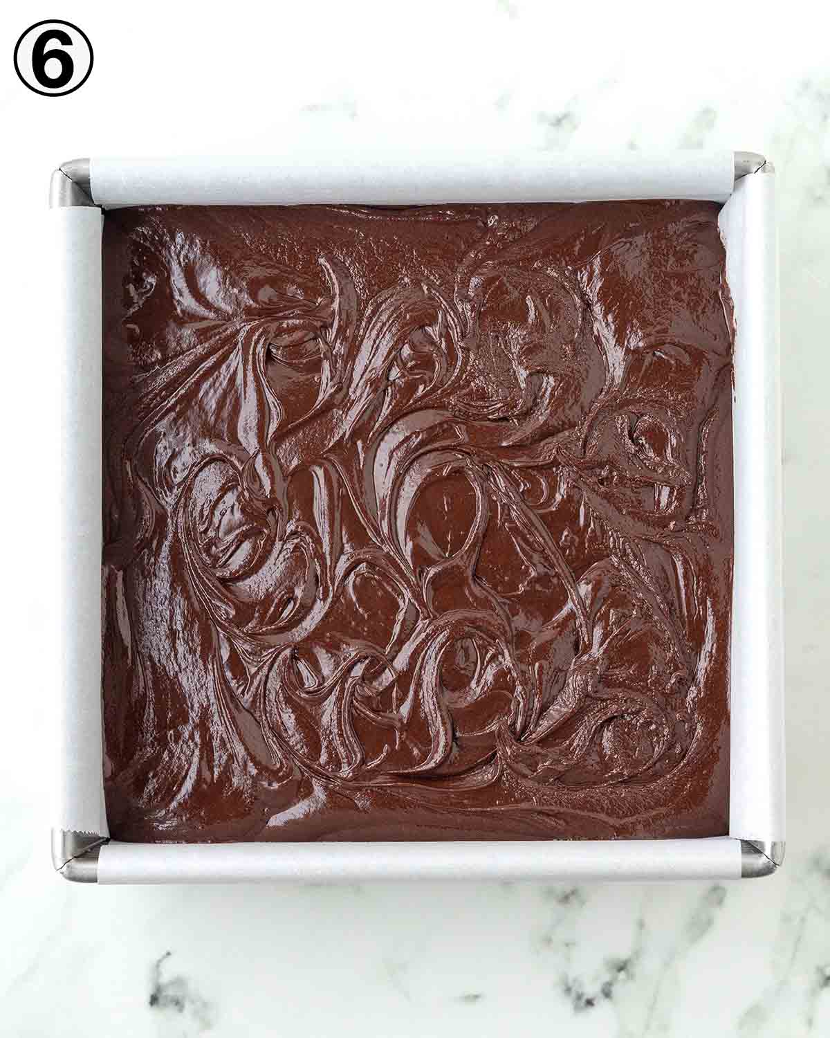 An overhead image of chocolate fudge in a square pan.