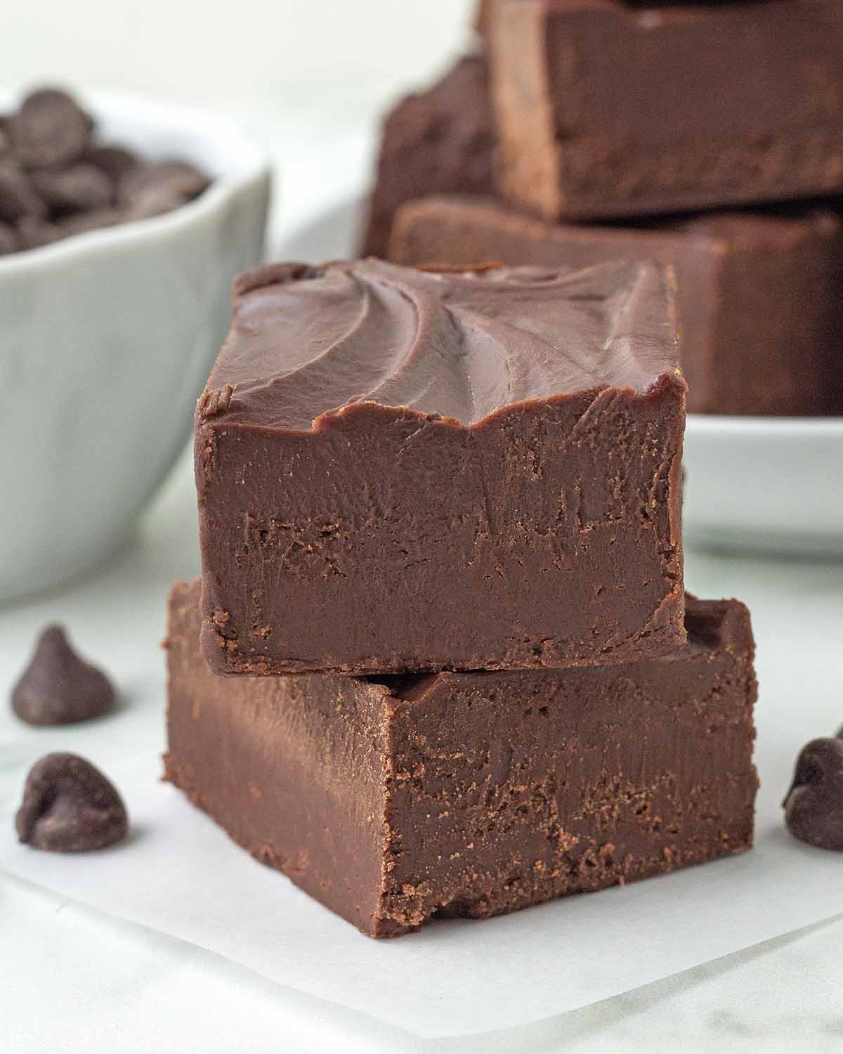Two pieces of easy vegan fudge on a white table.