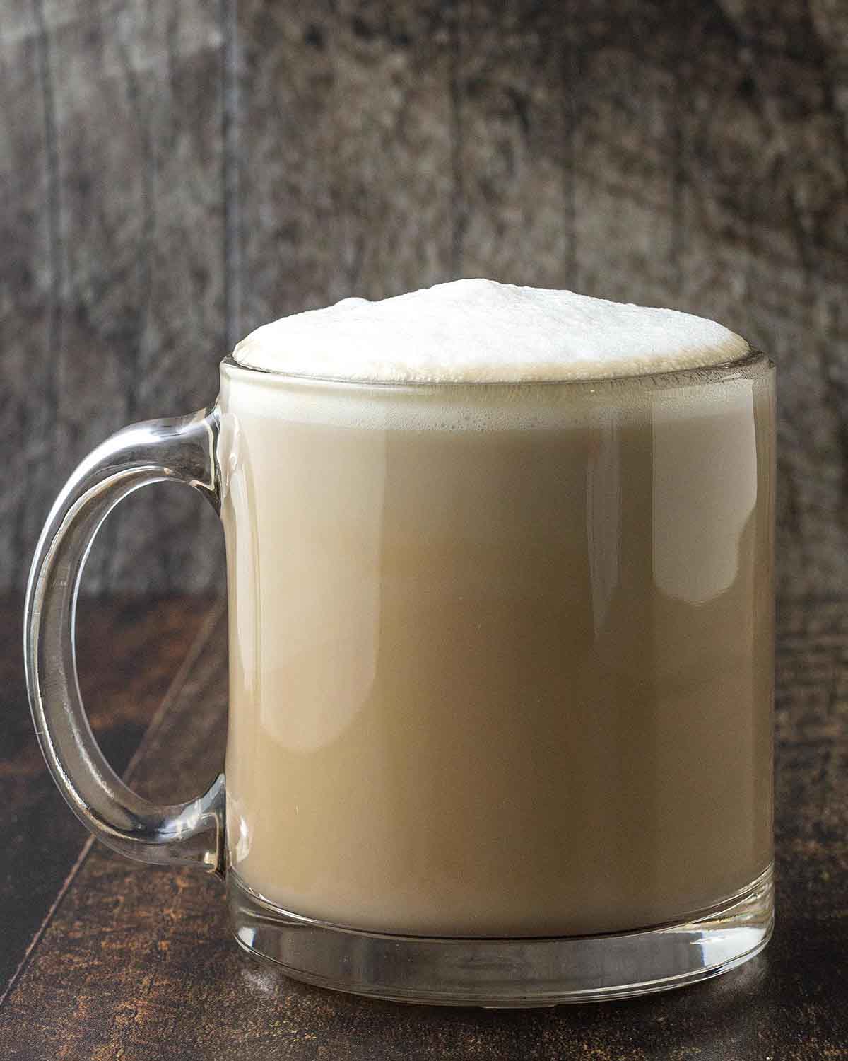 A homemade oat milk latte in a glass mug.