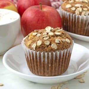 Close up shot of a vegan apple oatmeal muffin on a small white plate.