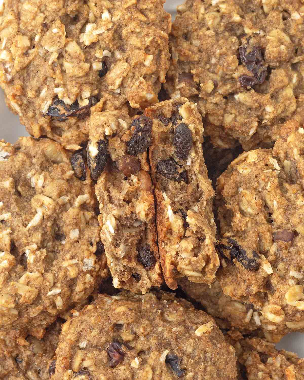 An overhead shot of banana oatmeal breakfast cookies, one is split in half to show the soft inner texture.