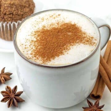 A close up of a vegan chai latte in a white mug.