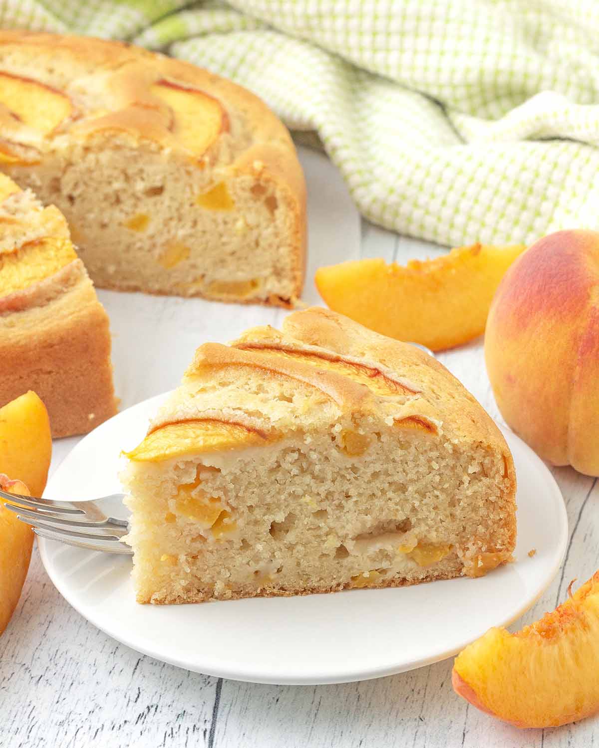 A slice of peach cake on a white plate.