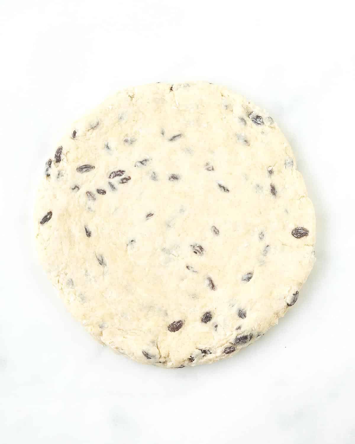 A rolled circle of uncut dough for vegan scones.