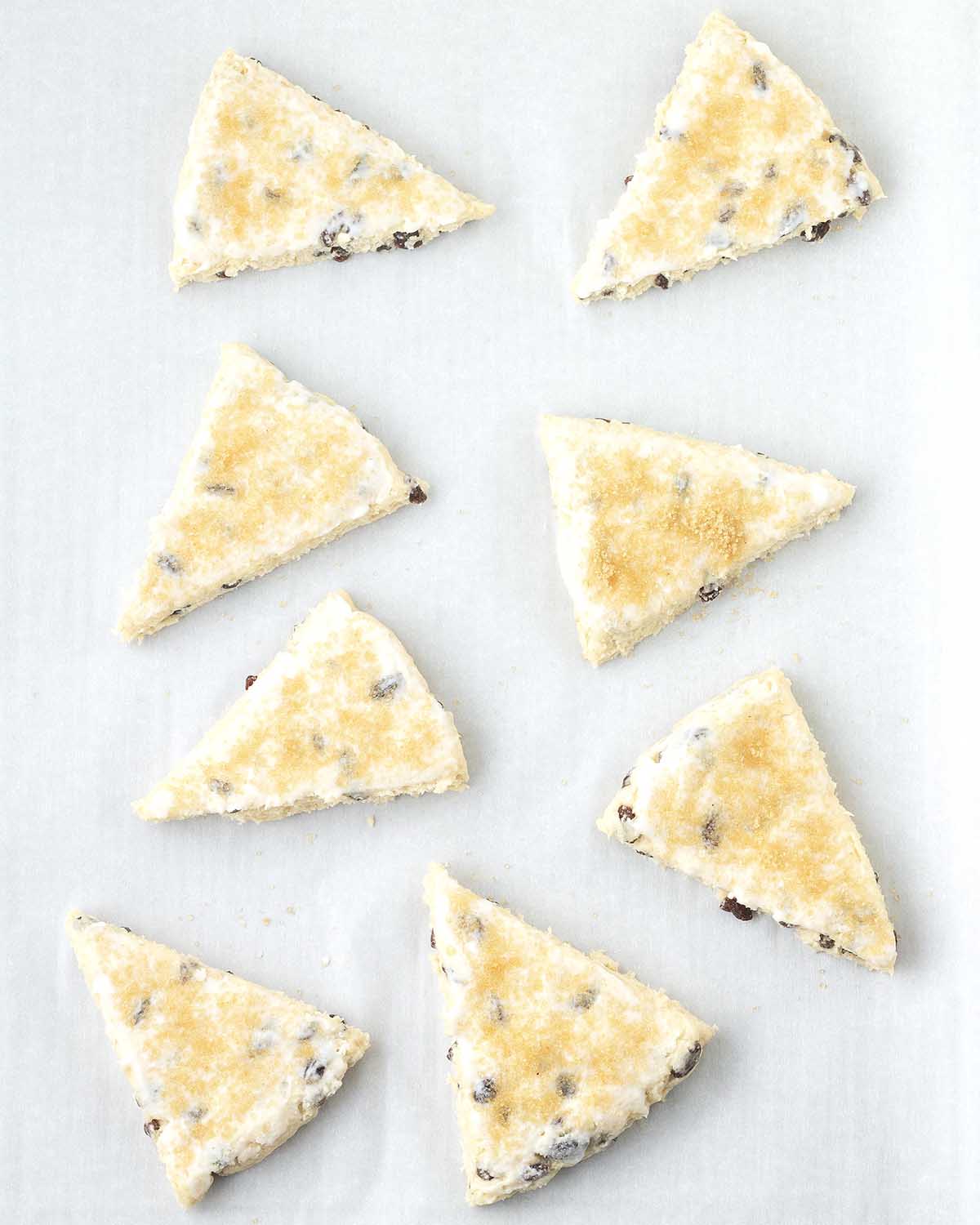Unbaked vegan scones on a parchment lined baking sheet.