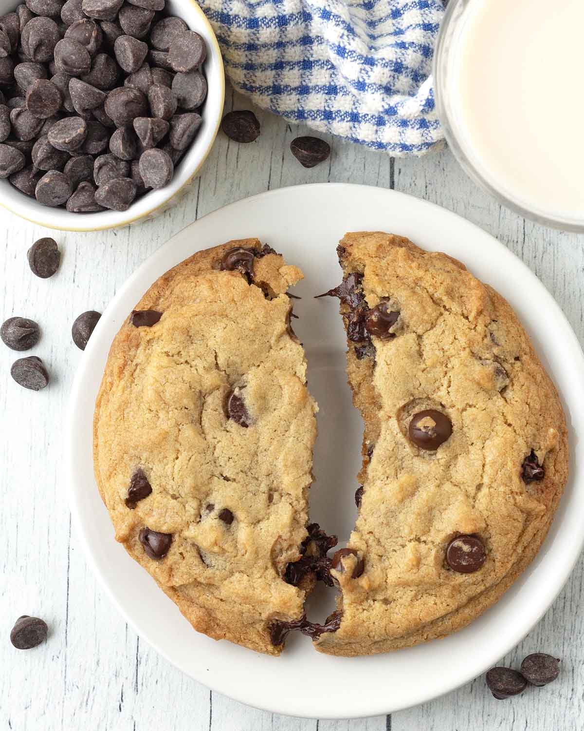 A cookie that has been split in two on a white plate.