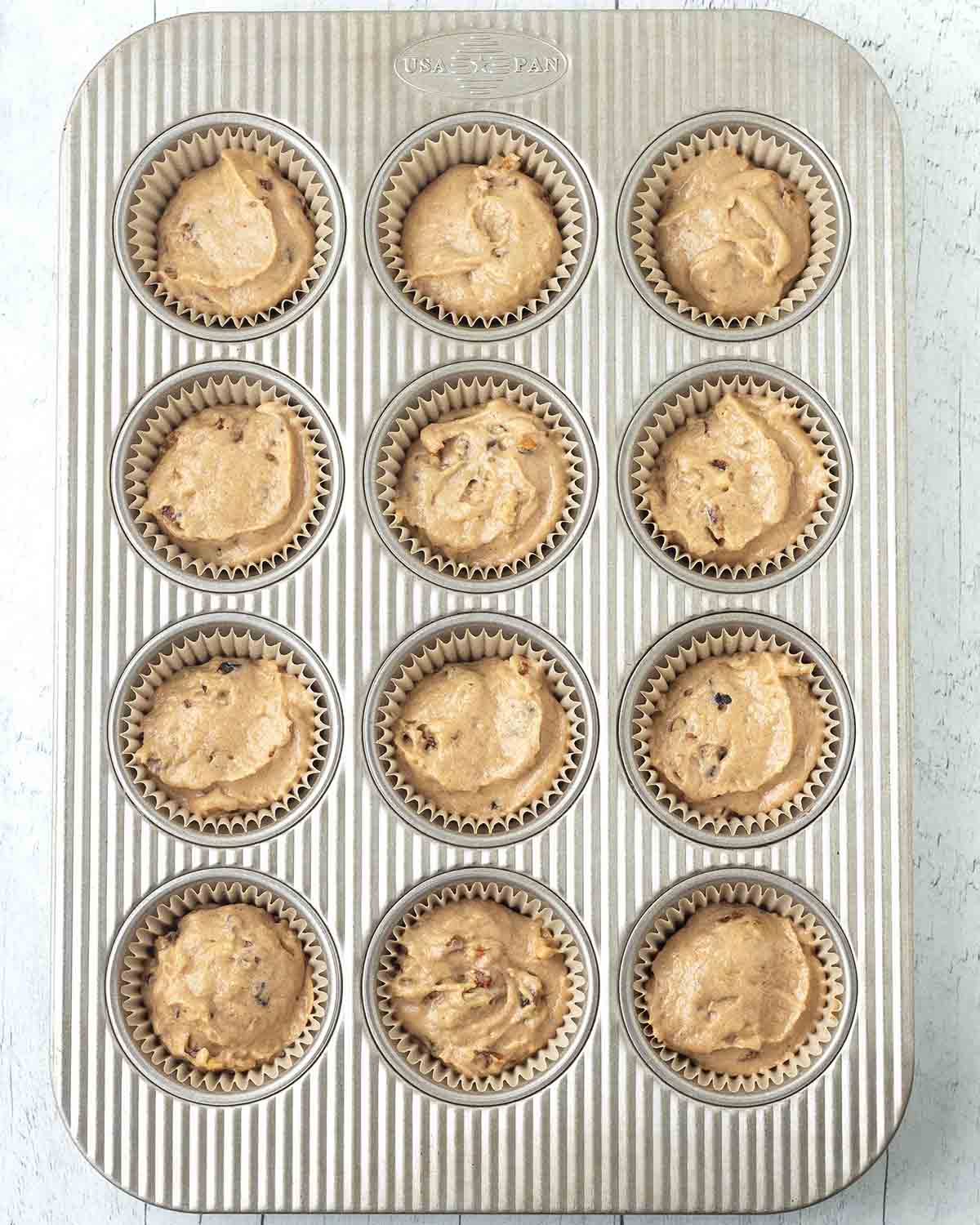 Unbaked banana muffins in a muffin pan.
