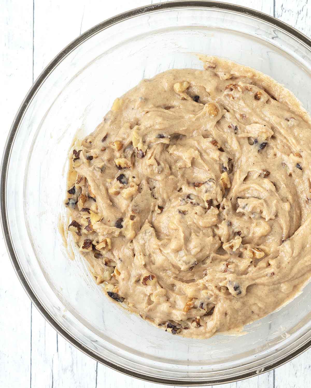 The mixed muffin batter for vegan banana muffins in a glass bowl.