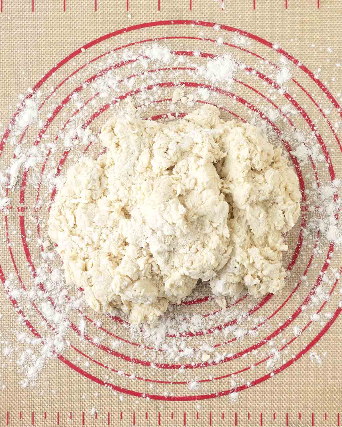 Shaggy biscuit dough just after being mixed on a pastry mat.