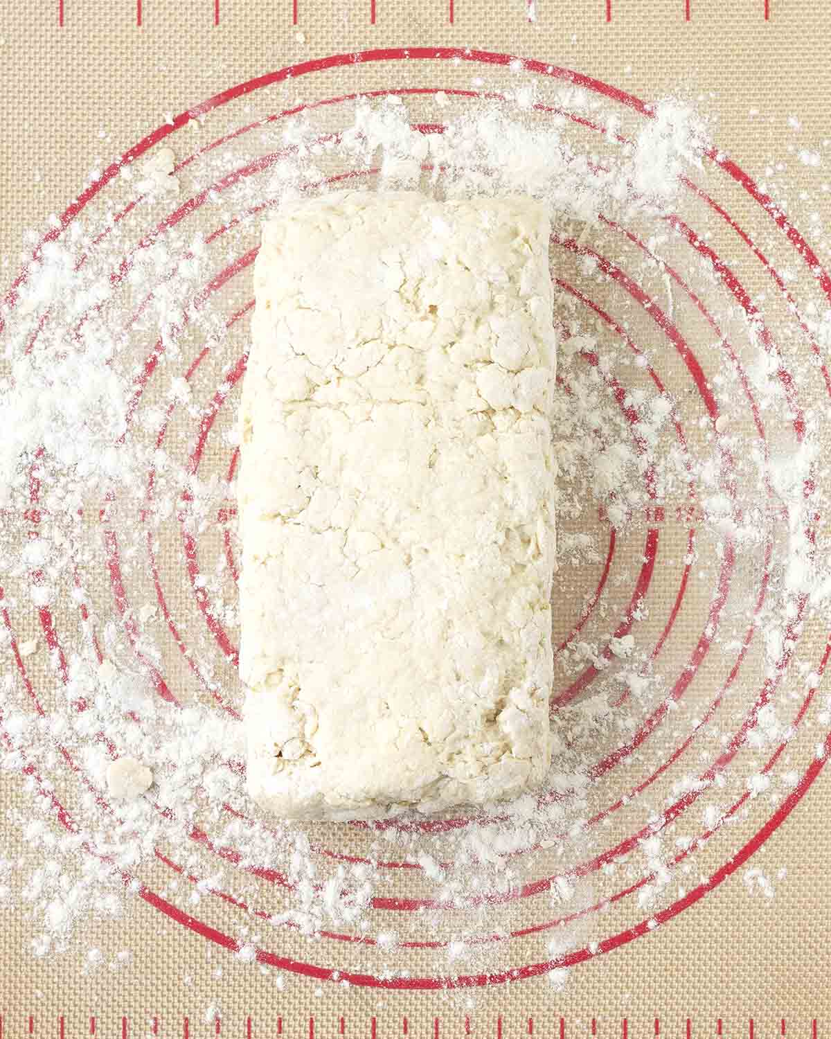 Folded biscuit dough on a floured pastry mat.