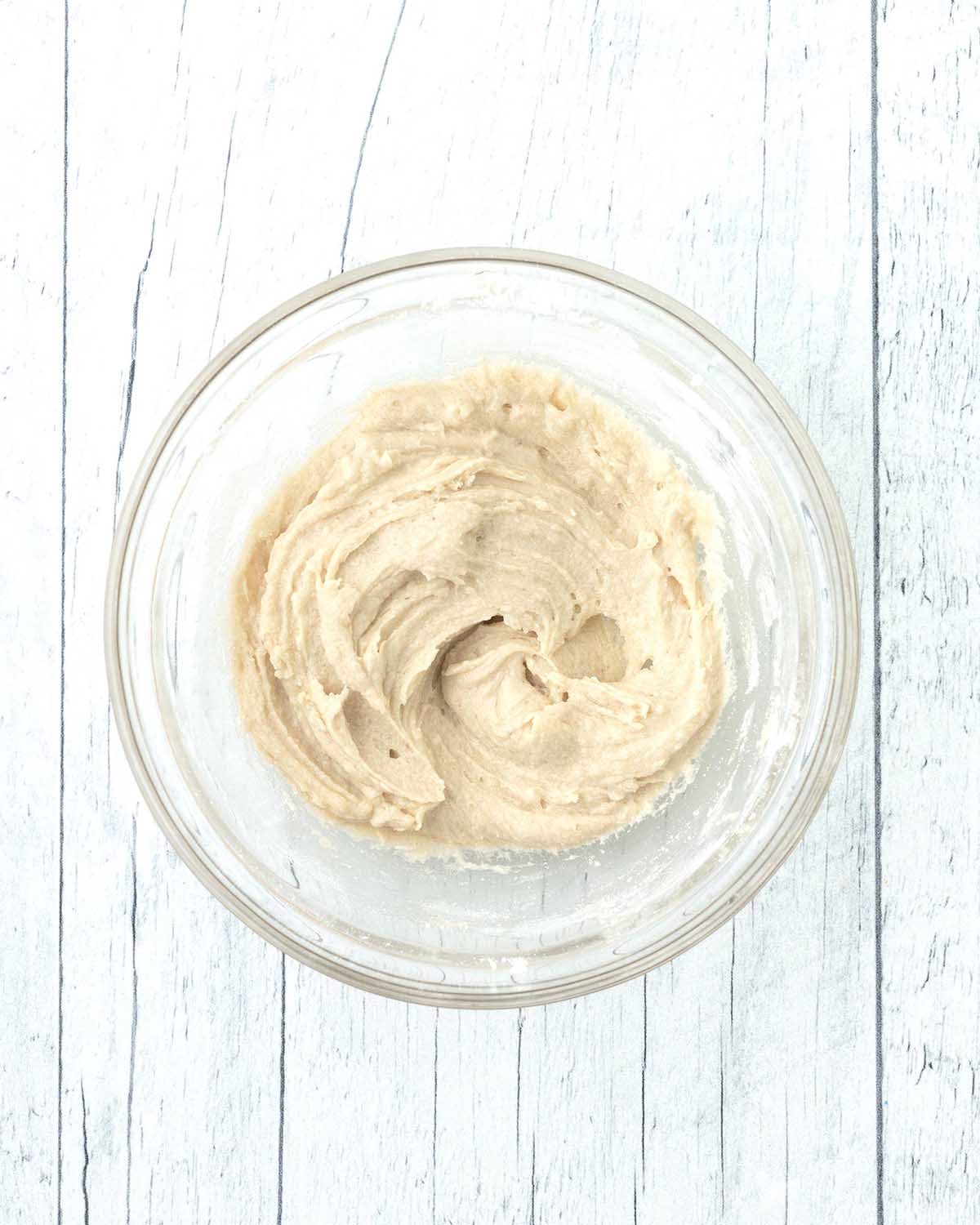 Mixed cookie dough in a glass bowl.