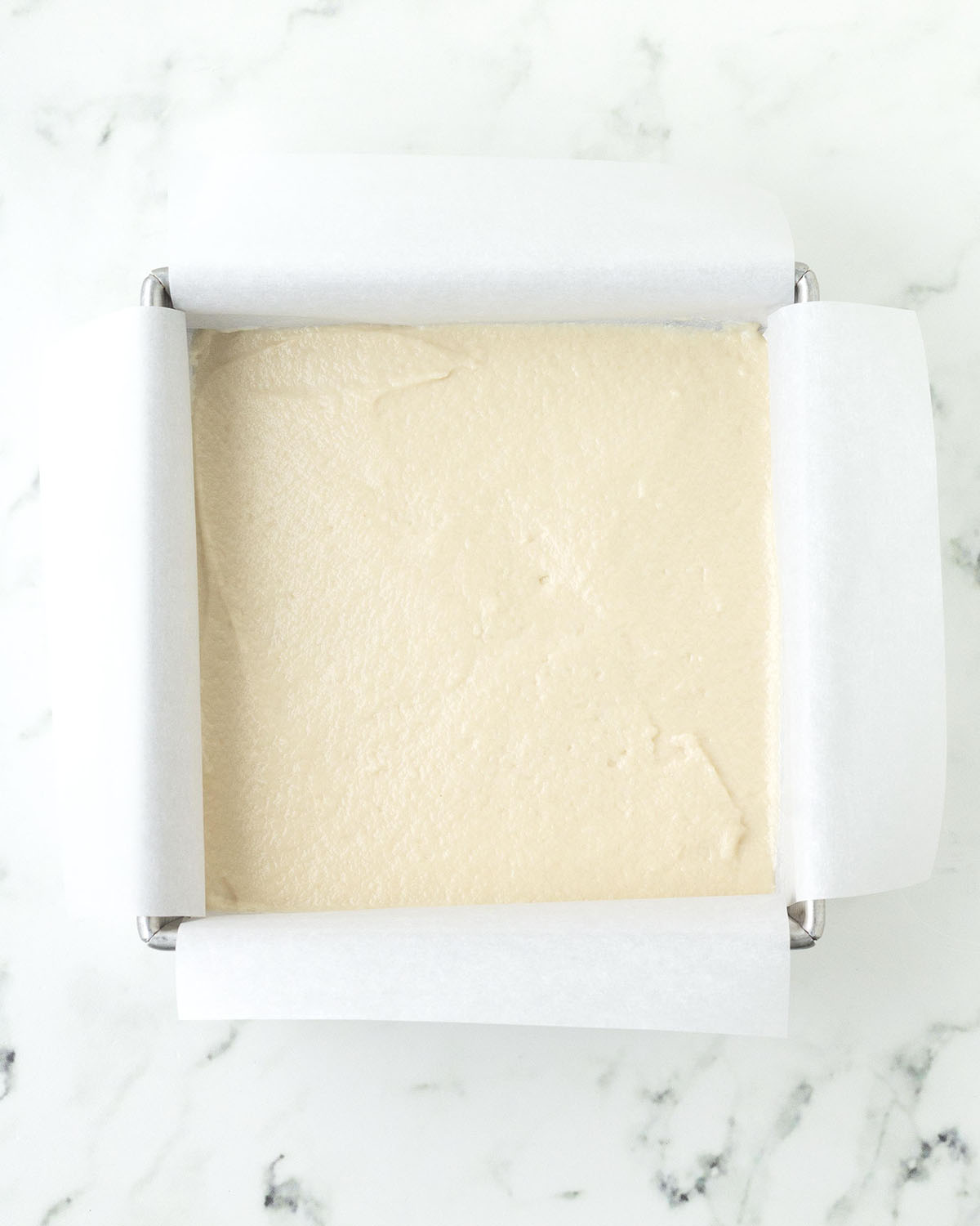 Cake batter in a square baking pan.