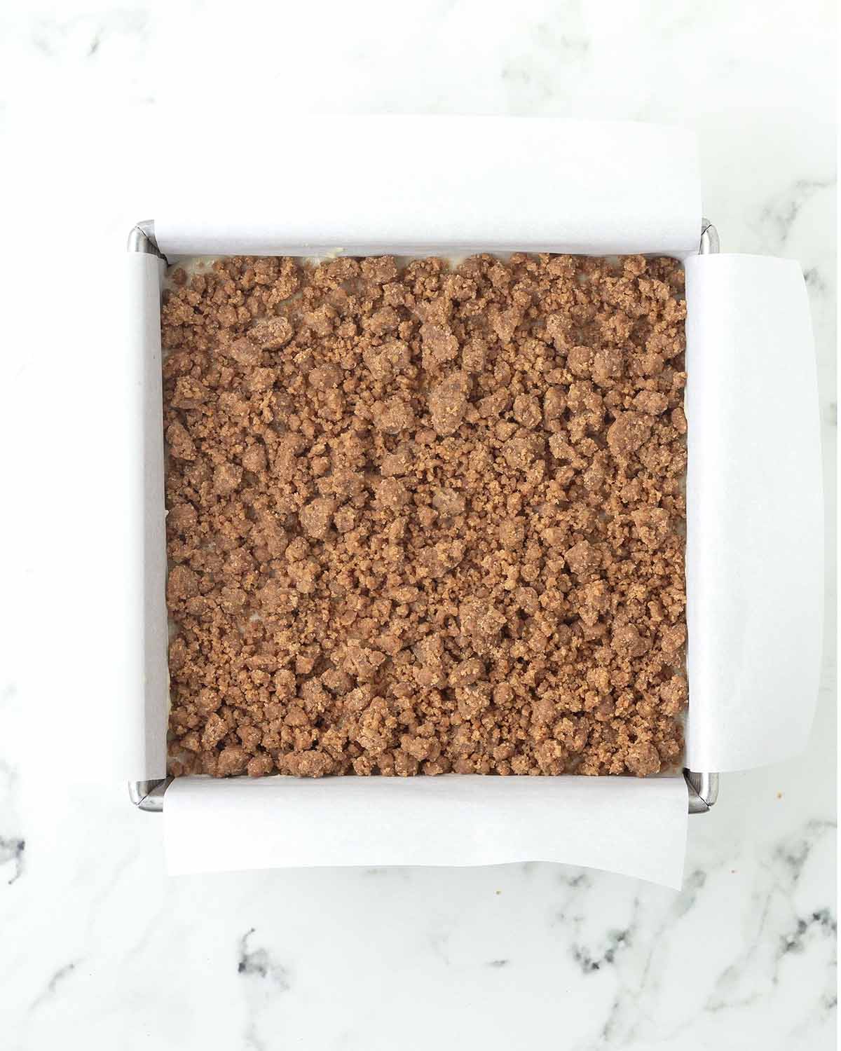 An unbaked coffee cake in a square pan.