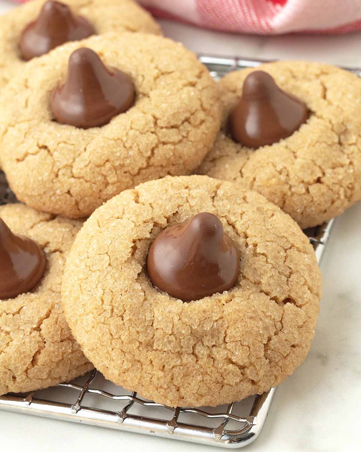 Peanut butter blossoms stacked on a cooling rack.