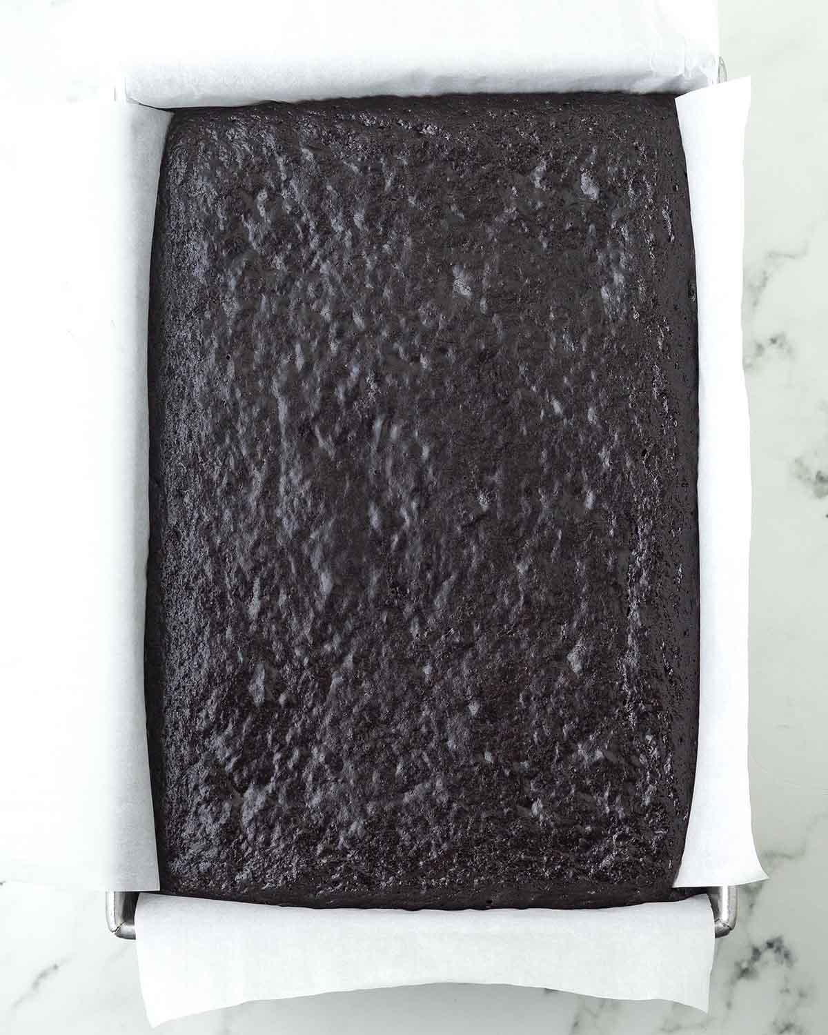 A freshly baked vegan chocolate sheet cake in a rectangle baking pan.