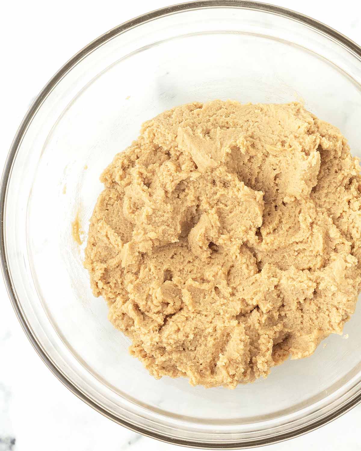 Peanut butter blossom cookie dough in a glass bowl.