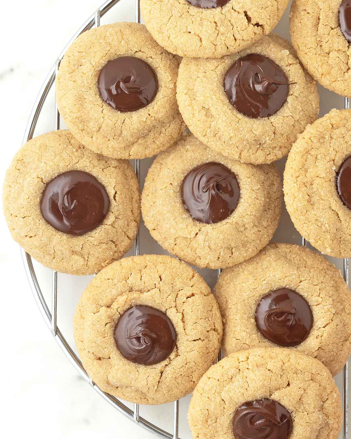 Peanut butter blossom cookies on a round cooling rack.