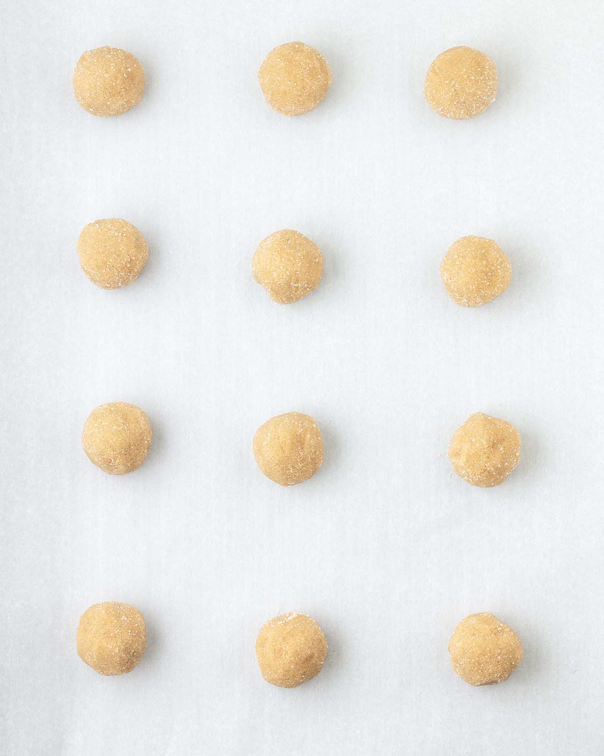 Rolled peanut butter blossom cookie balls just before being baked.