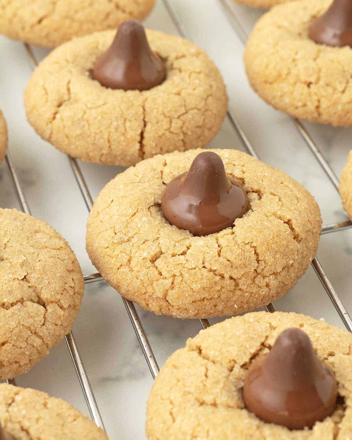 Peanut butter blossom cookies on a metal cooling rack.