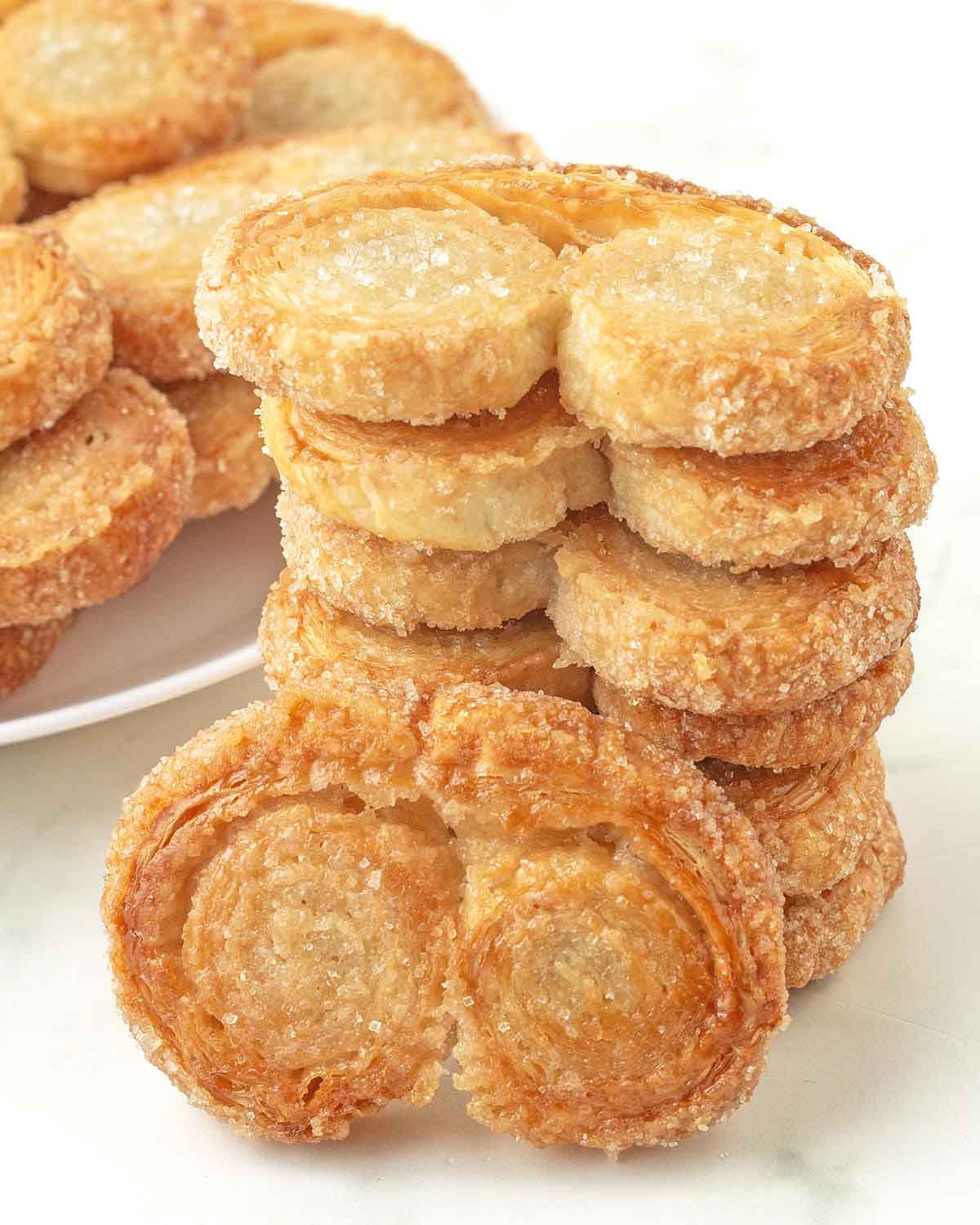 A stack of six vegan palmiers, one palmier is leaning on the stack.