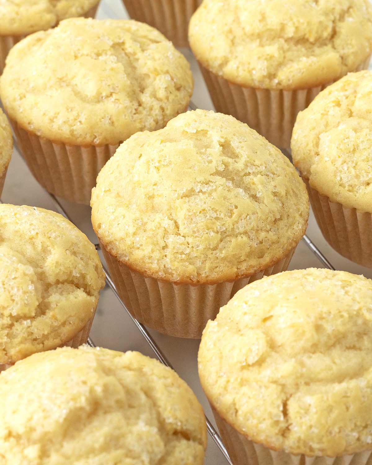 Freshly baked vegan lemon muffins cooling on a metal rack.