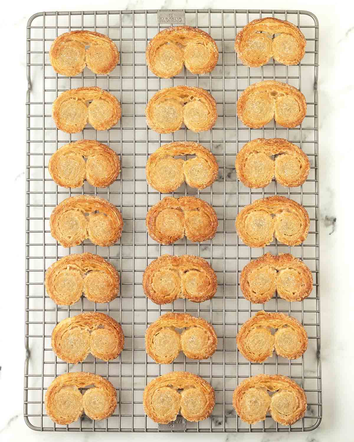 Freshly baked vegan palmiers on a metal cooling rack.