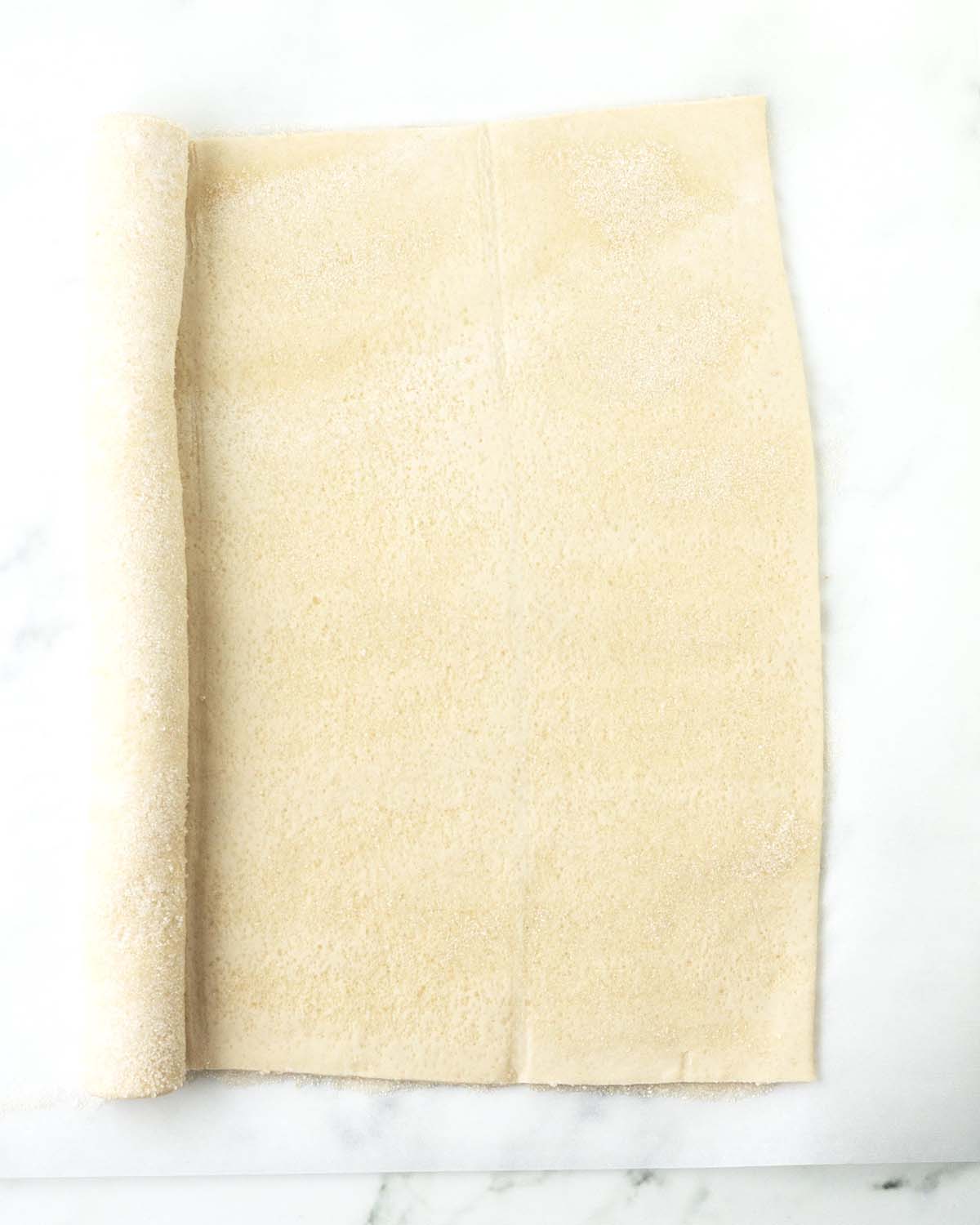 A half rolled up sheet of puff pastry.