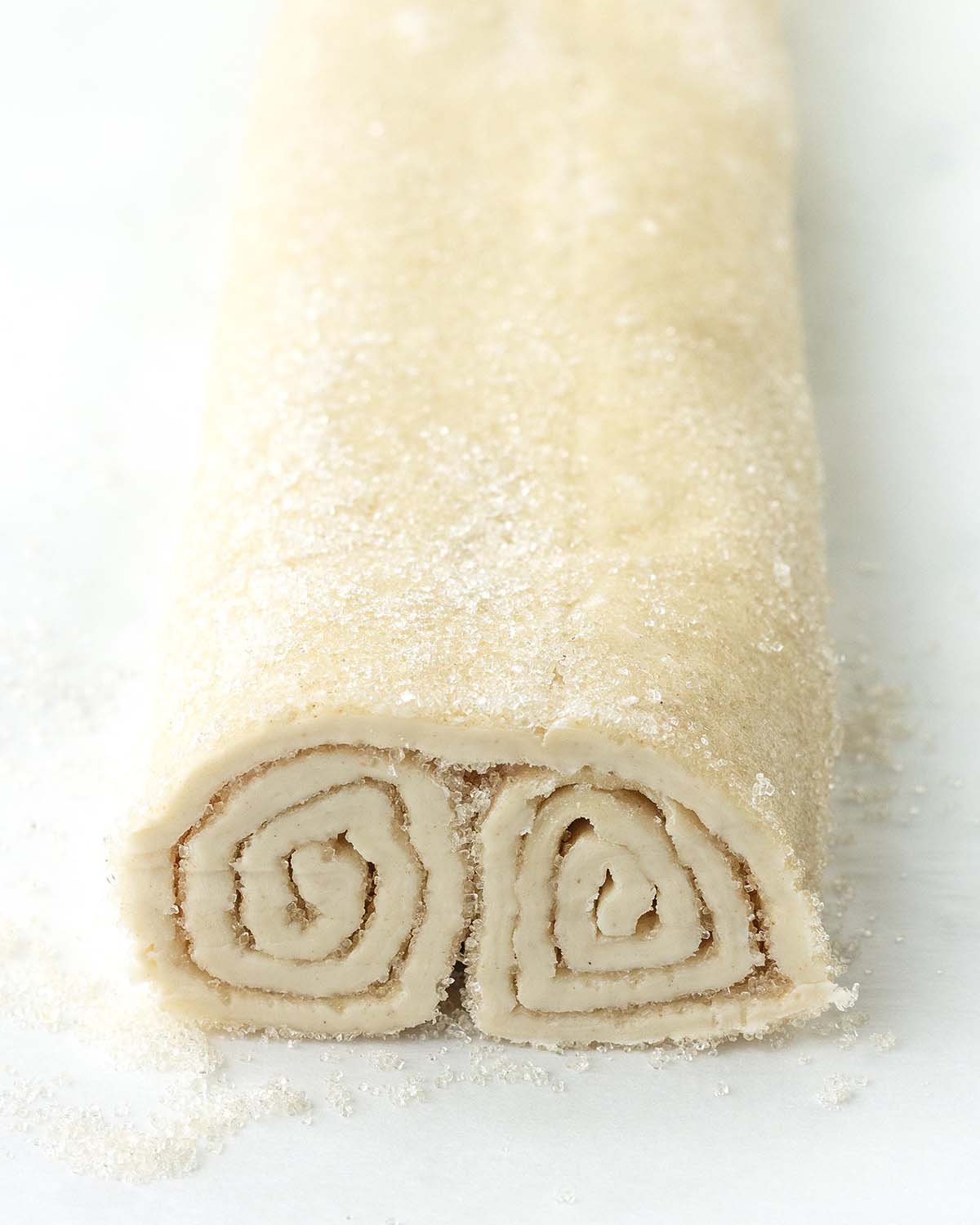 A close up to show how to place the log of puff pastry upside down before slicing the palmiers.
