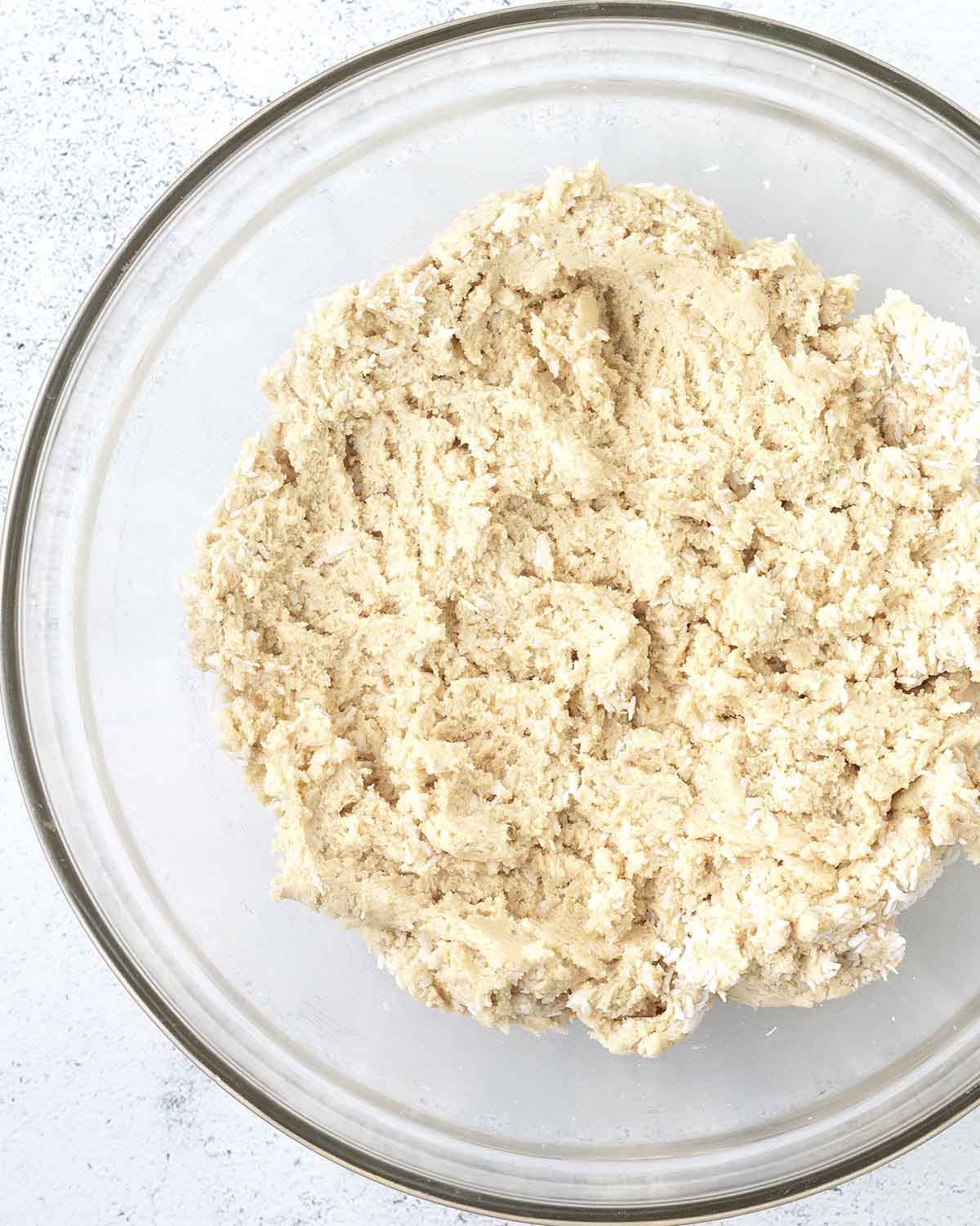Coconut cookie dough in a glass bowl.