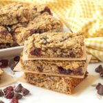 A stack of three granola bars with pieces of parchment paper between each one.