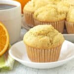 A vegan orange muffin sitting on a small white plate.