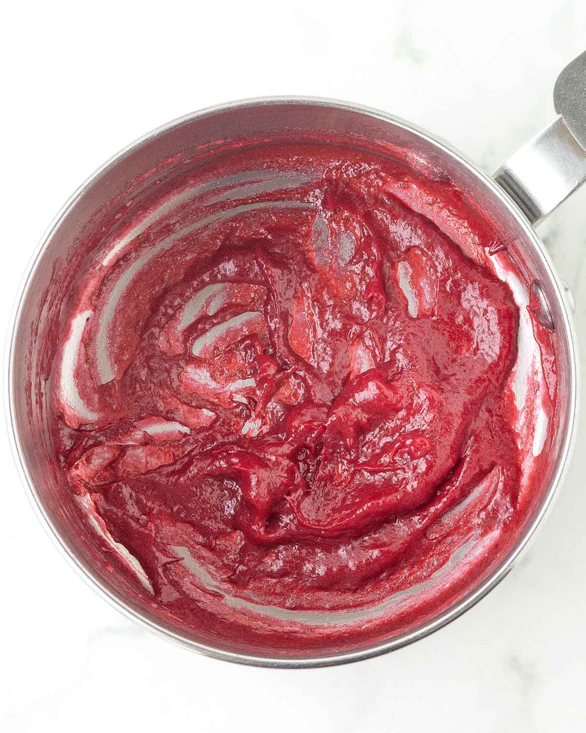 Reduced raspberry puree in a pot.