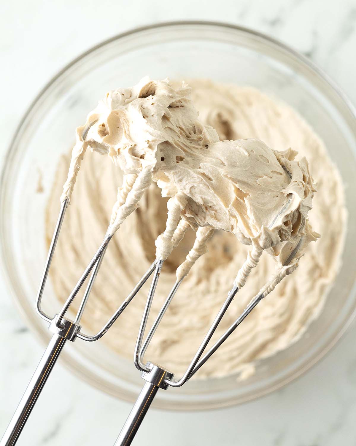Coffee frosting on the beaters of an electric mixer.