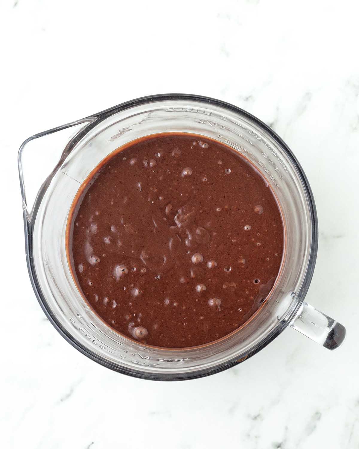 Vegan chocolate cupcake batter in a glass measuring bowl.