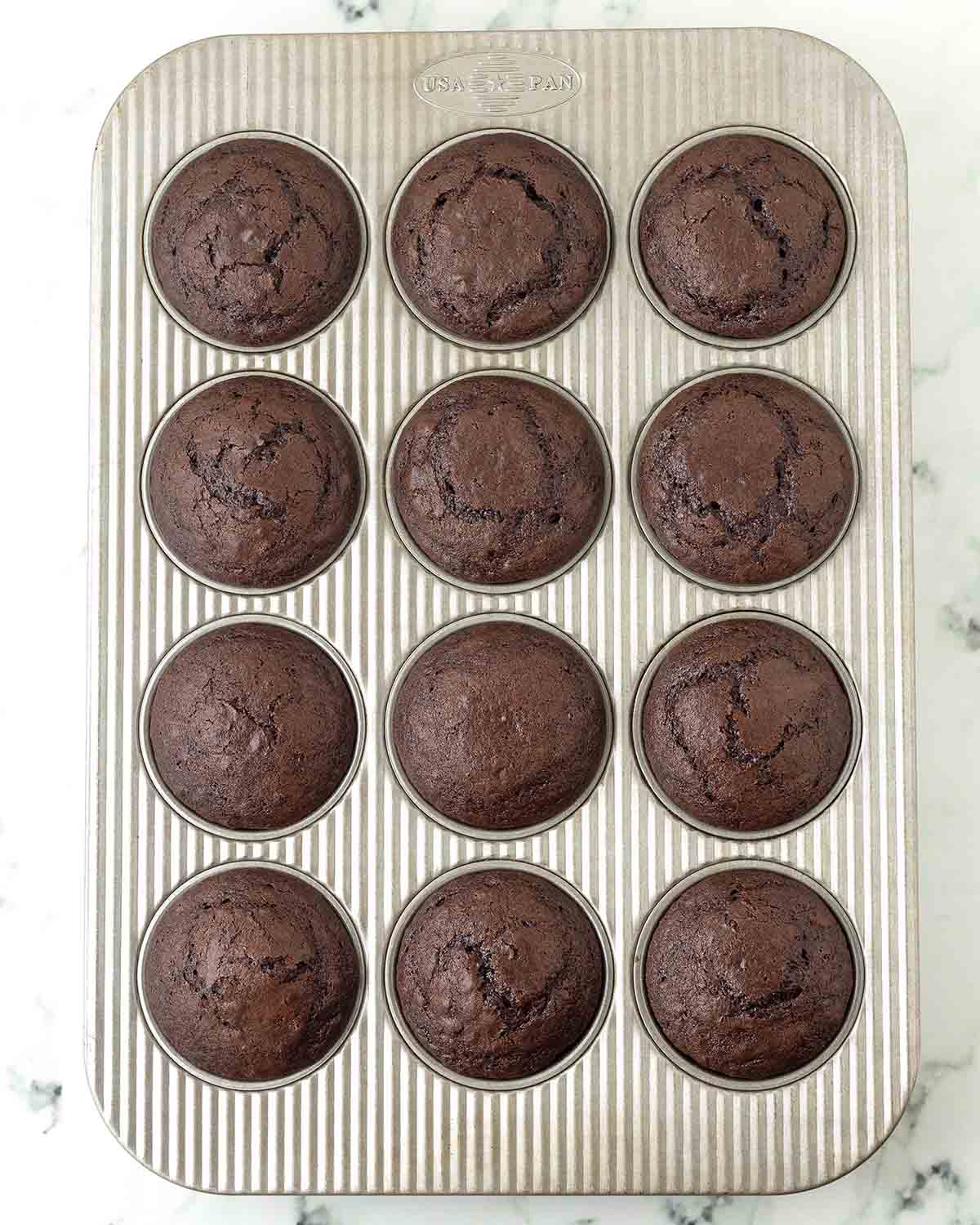 Freshly baked chocolate cupcakes in a cupcake pan.