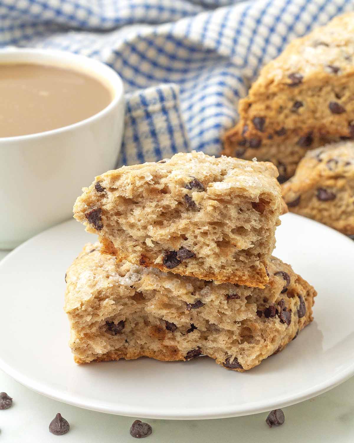 A vegan chocolate chip scone split in half to show the soft inner texture.