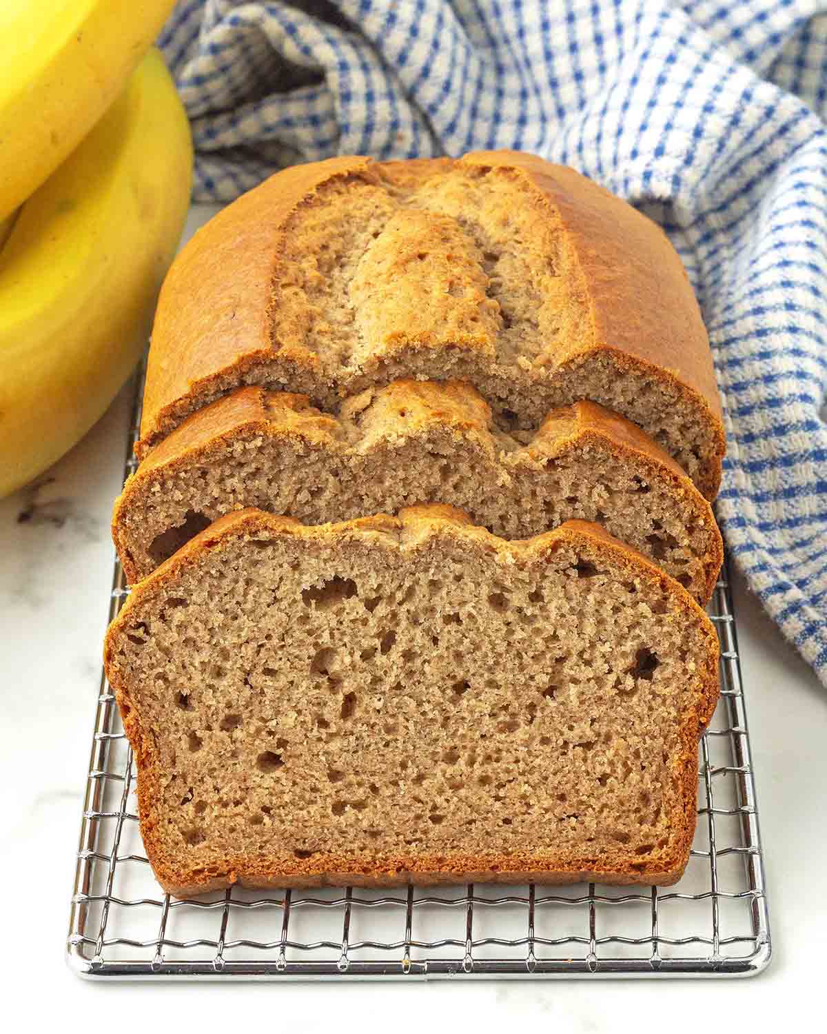 Two slices of banana bread leaning backwards against the rest of the loaf.