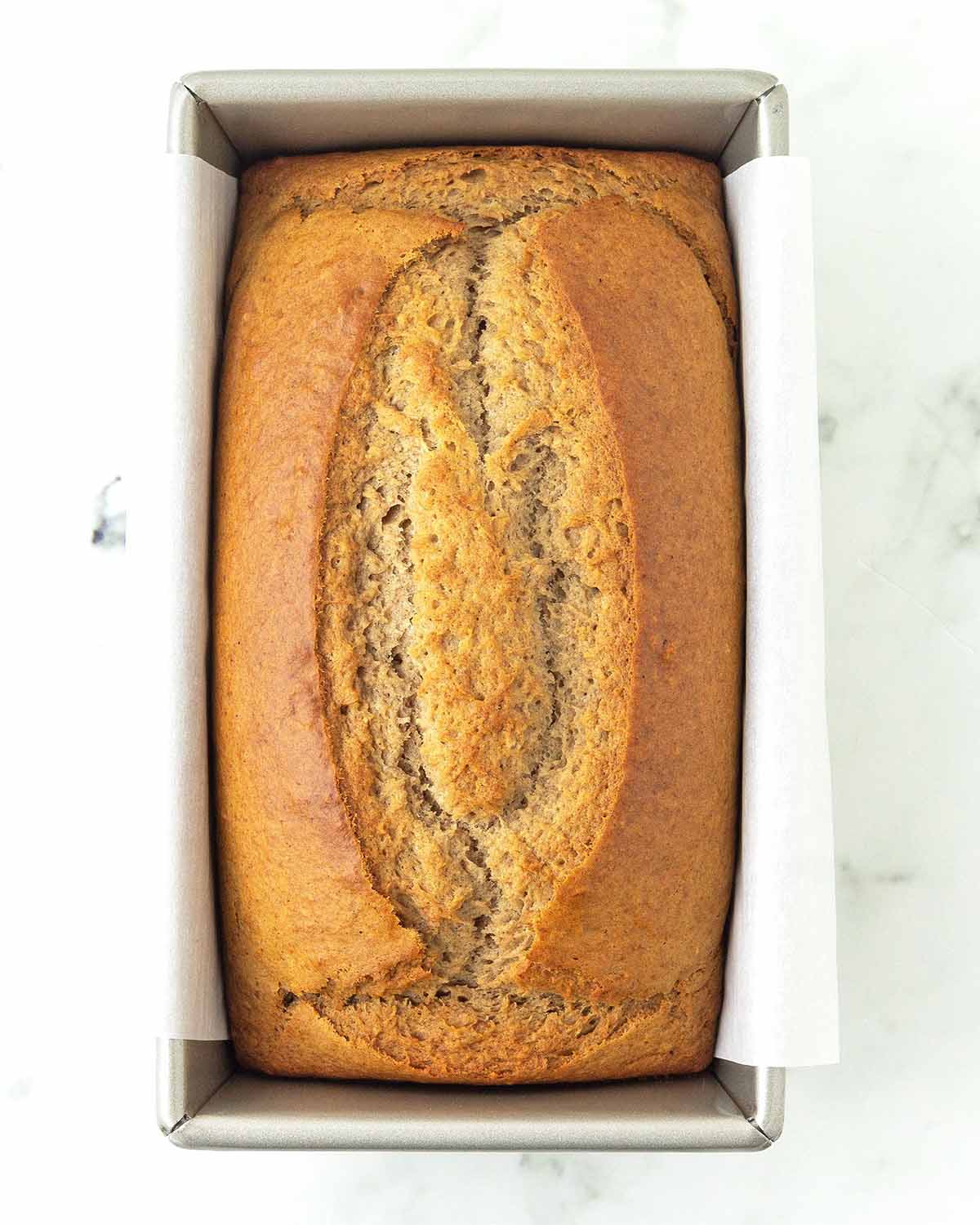 An overhead image of a freshly baked banana bread still in its baking pan.