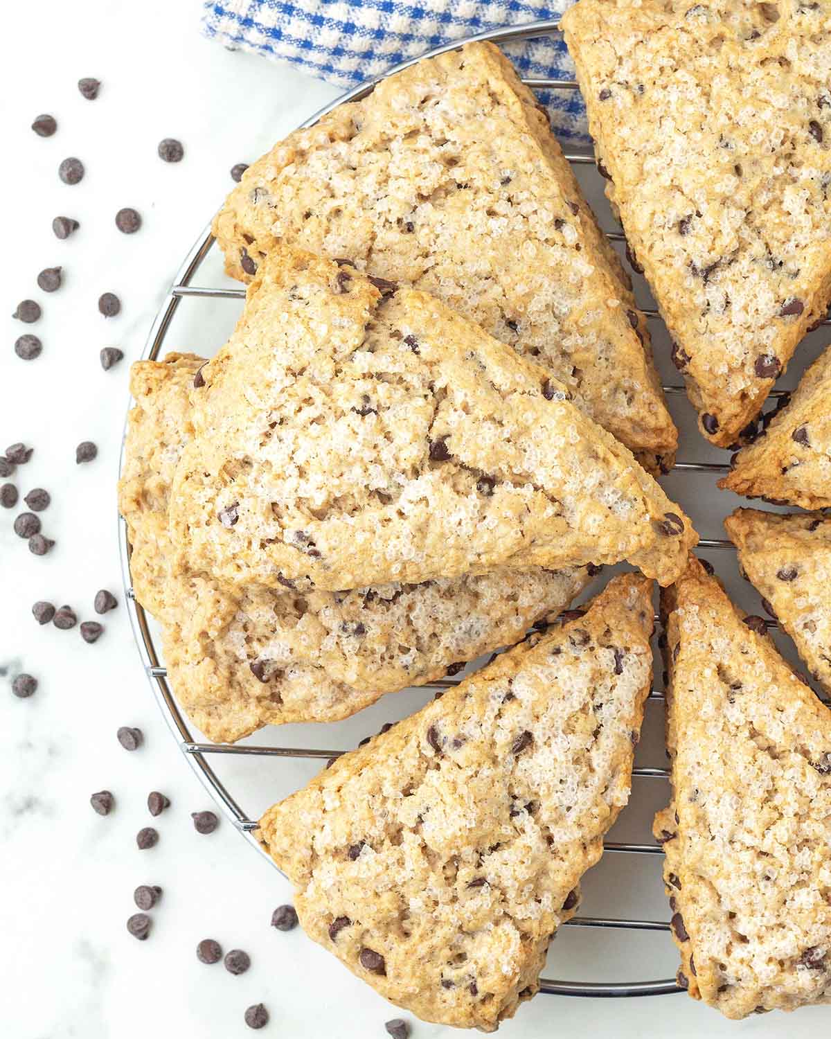 Vegan chocolate chip scones stacked on top of a circle metal rack.