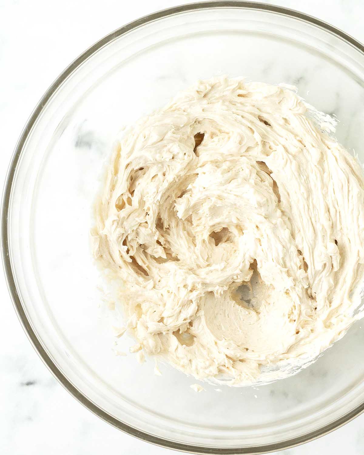 Mixed butter and sugar in a glass bowl.