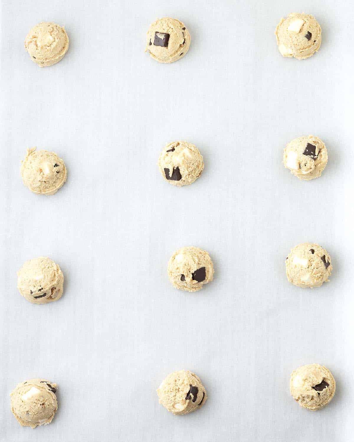Raw smores cookie dough balls on a cookie sheet.