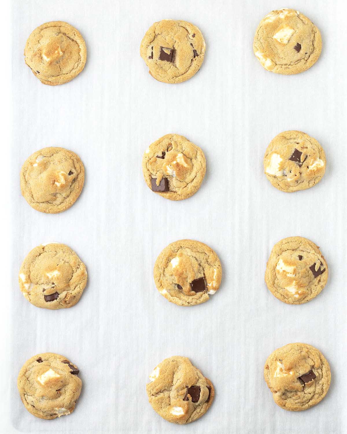 Freshly baked vegan smores cookies on a parchment lined cookie sheet.