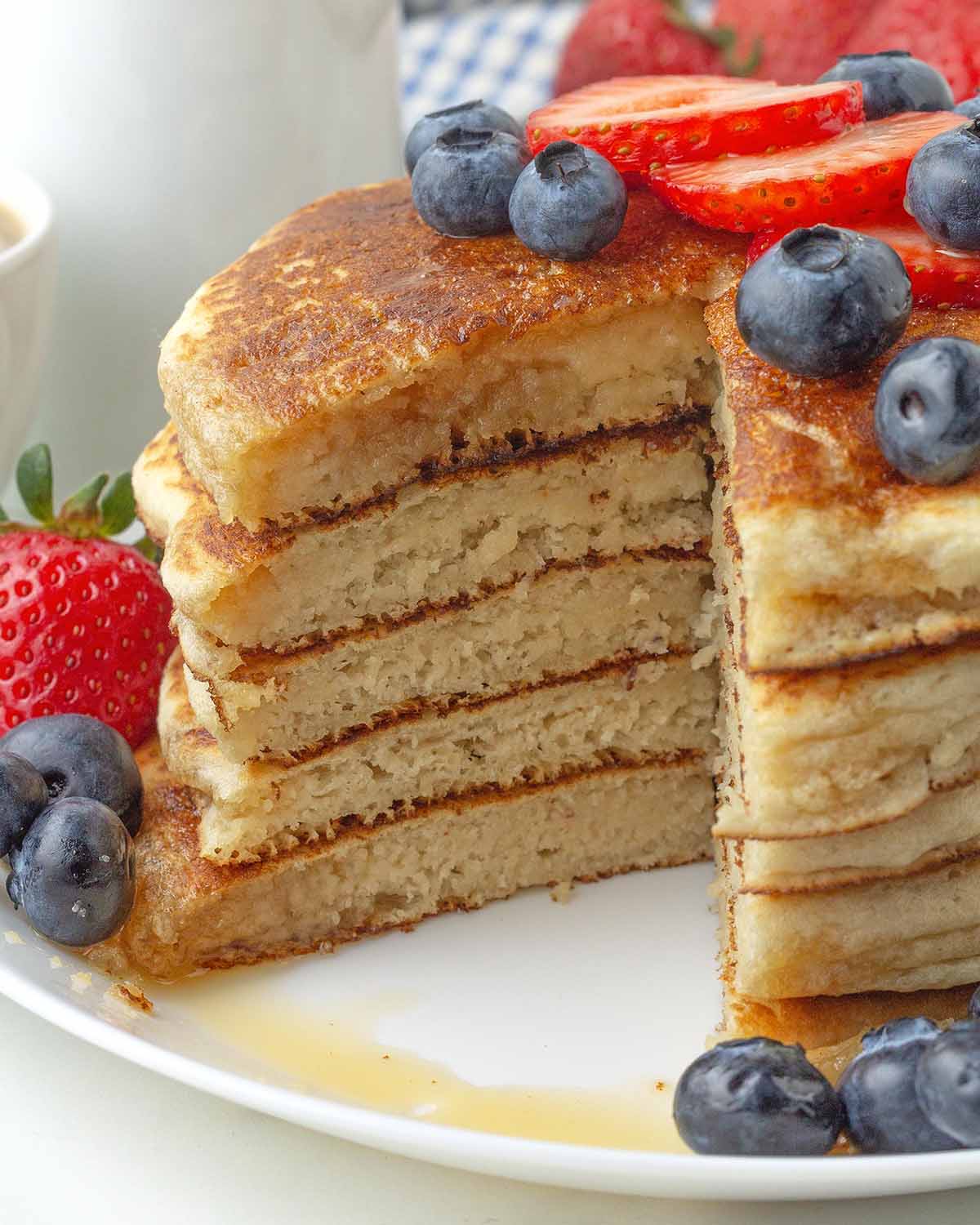 Five almond flour pancakes that have had a wedge cut of out them to show the fluffy interior.